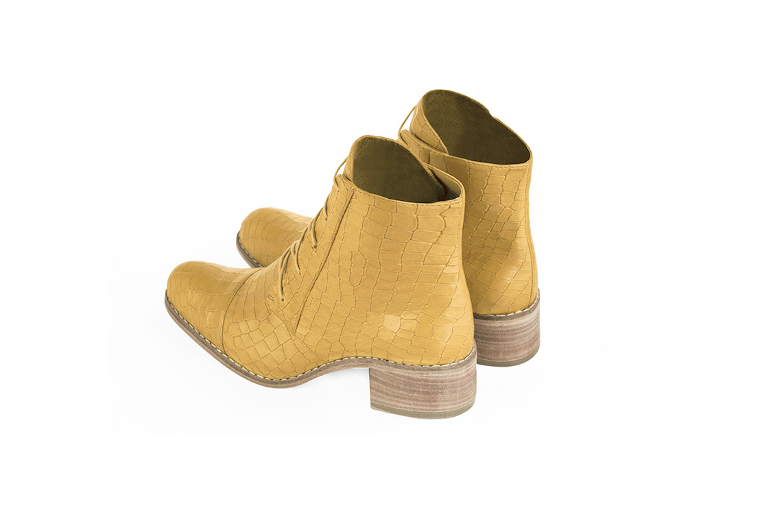 Mustard yellow women's ankle boots with laces at the front. Round toe. Low leather soles. Rear view - Florence KOOIJMAN